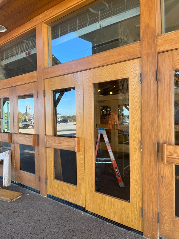 A wood door being repaired at the entrance of Cabela's Bass Pro Shops