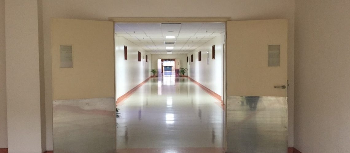 Hospital corridor featuring swinging metal doors