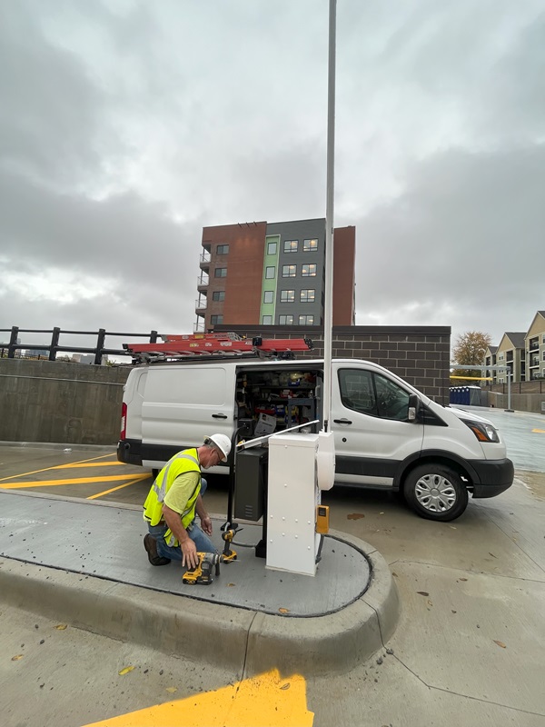 Technician sets up gate access hardware at parking lot
