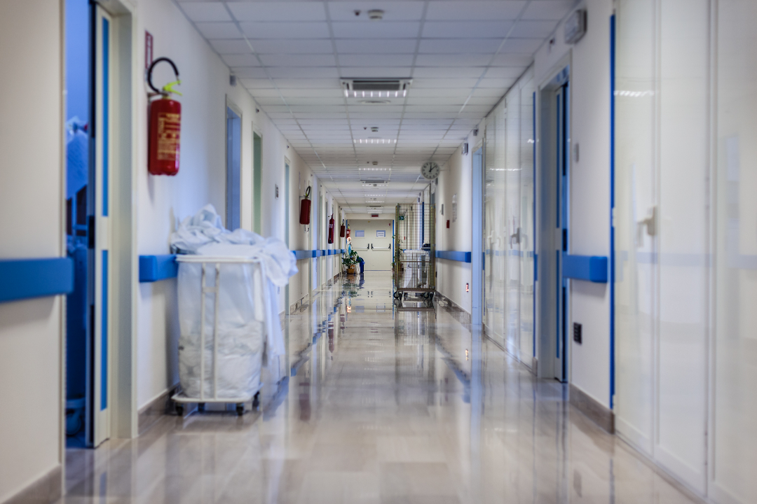 Hospital corridor with metal doors at the end
